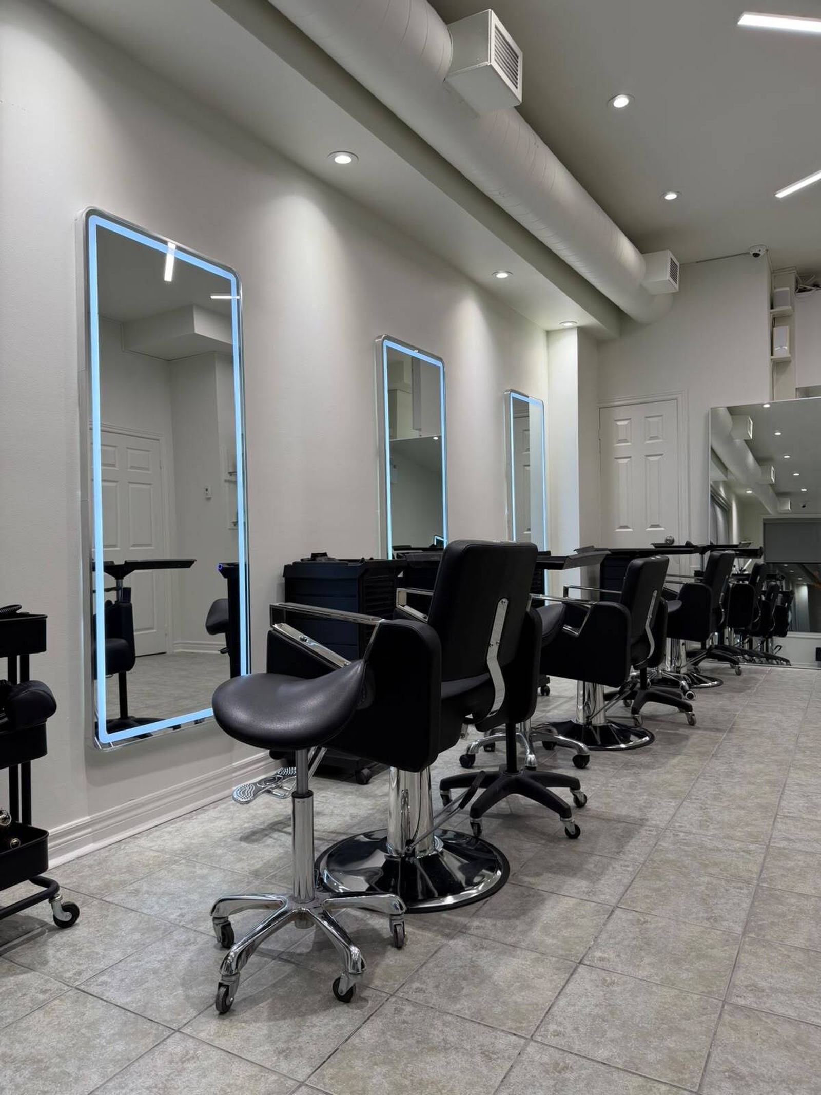 Inside One Four Studio: black styling chairs along a row of tall lit mirrors